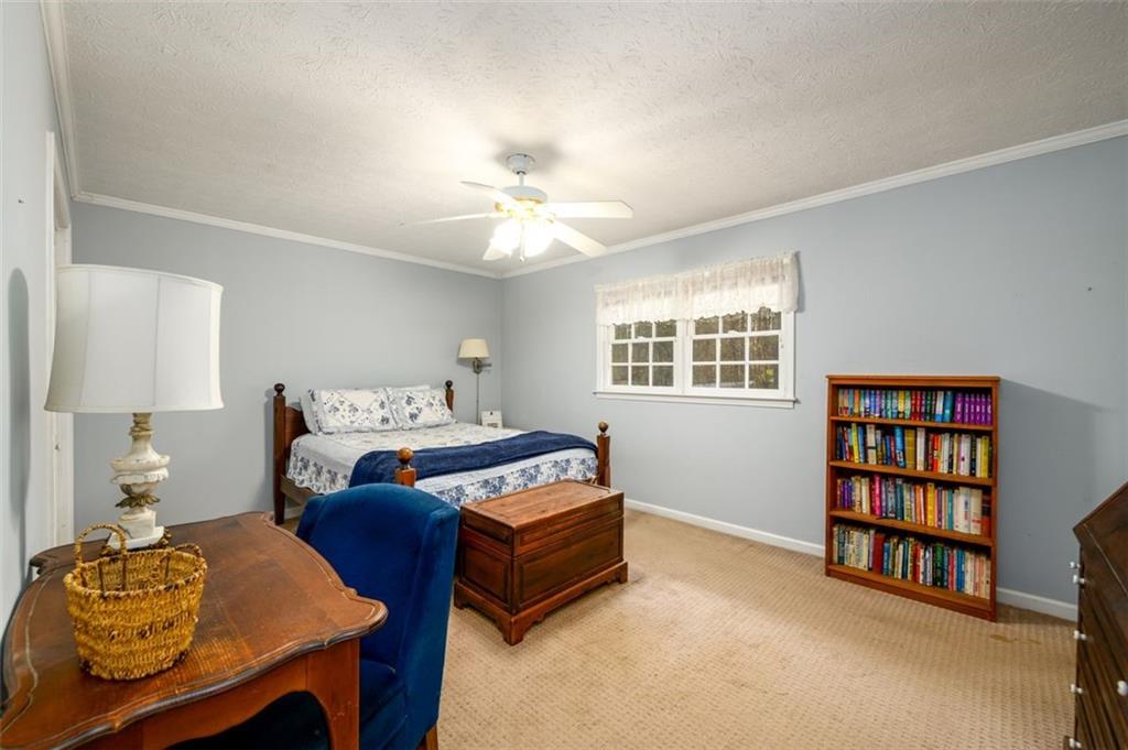 4304 Riverside Drive Southwest Lilburn, GA 30047 - Photo 19 of 33 a bedroom with a bed a dresser and a book shelf