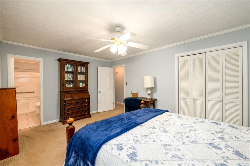 4304 Riverside Drive Southwest Lilburn, GA 30047 - Photo 20 of 33 a bedroom with a bed and a chandelier