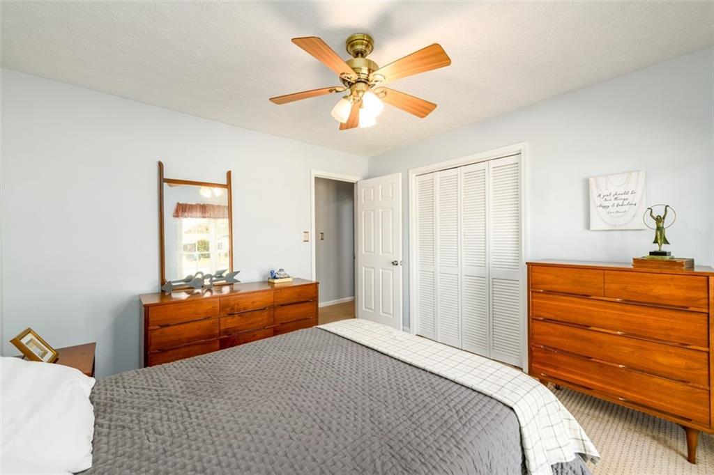 4304 Riverside Drive Southwest Lilburn, GA 30047 - Photo 23 of 33 a bedroom with a bed and ceiling fan
