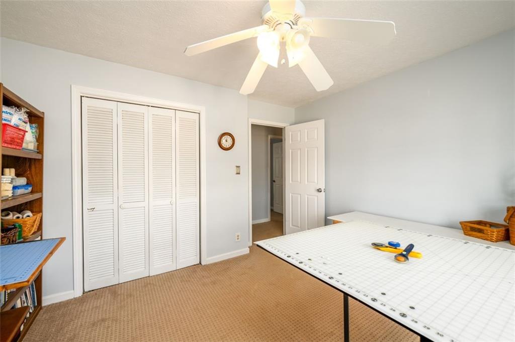 4304 Riverside Drive Southwest Lilburn, GA 30047 - Photo 25 of 33 a bedroom with a bed and a chandelier