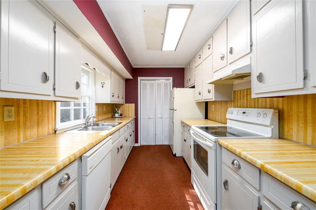 4304 Riverside Drive Southwest Lilburn, GA 30047 - Photo 8 of 33 a kitchen with a stove a sink and a refrigerator