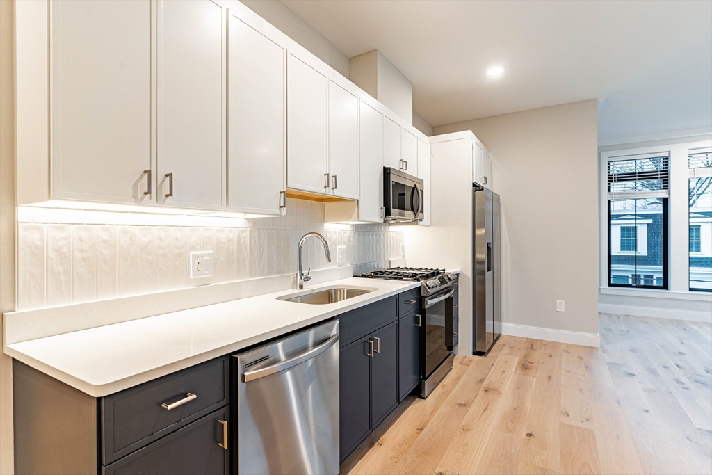 a kitchen with a sink a stove and a refrigerator