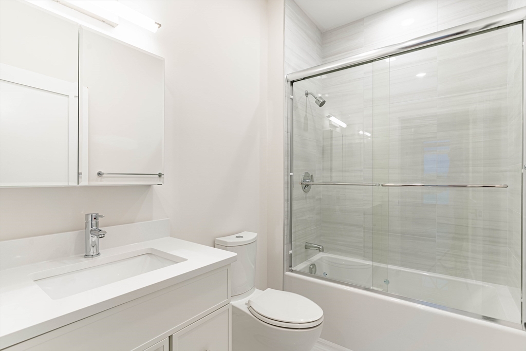 157 Everett Street, Unit 302 Boston, MA 02134 - Photo 10 of 11 a bathroom with a sink mirror bathtub and toilet