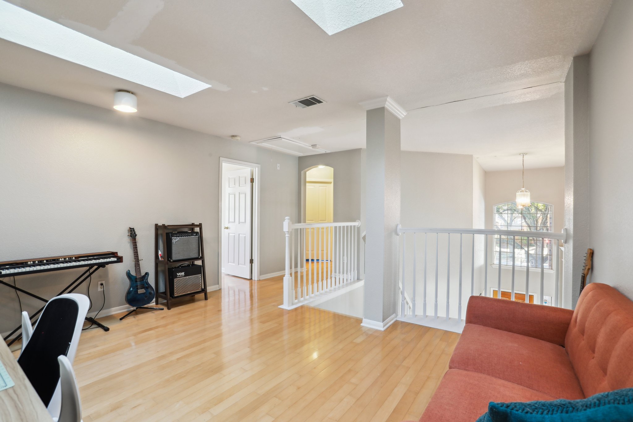 13541 Anarosa Loop Austin, TX 78727 - Photo 18 of 27 Spacious interior room featuring light wood-finish flooring, white walls, and two skylights