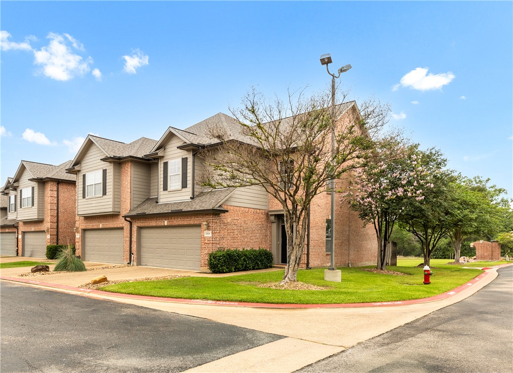 1425 West Villa Maria Road, Unit 1004 Bryan, TX 77801 - Photo 1 of 23 a view of a white house with a yard and plants