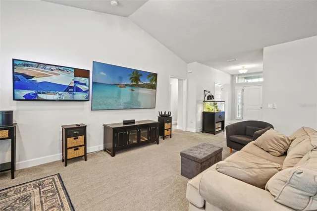 a living room with stainless steel appliances furniture a couch and a view of kitchen
