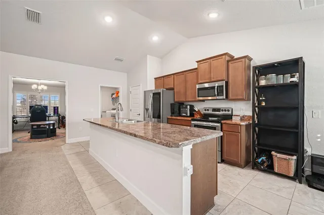a kitchen with stainless steel appliances granite countertop a refrigerator oven stove top oven and couches