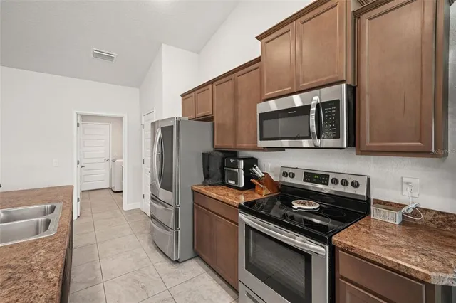 a kitchen with stainless steel appliances granite countertop a stove a sink and a microwave