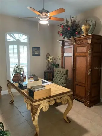 a dining room filled a chandelier and kitchen view