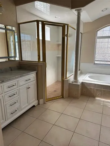 a bathroom with a granite countertop sink a mirror and a bathtub
