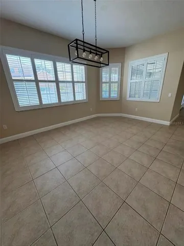 an empty room with windows and ceiling fan
