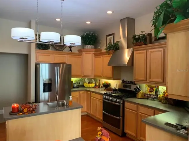 a kitchen with stainless steel appliances granite countertop a stove a sink and a refrigerator