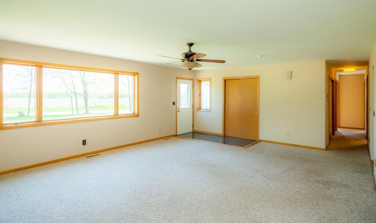 18660 Burr Oak Road Capron, IL 61012 - Photo 5 of 25 an empty room with chandelier fan and windows