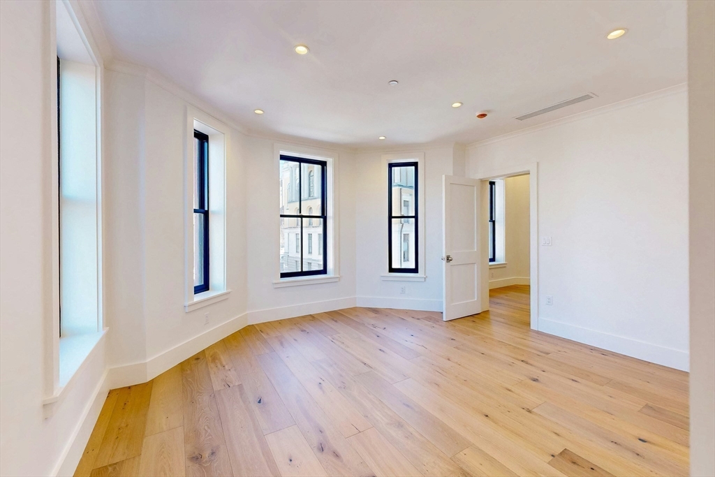 57 Hancock Street Boston, MA 02114 - Photo 30 of 42 an empty room with wooden floor and windows