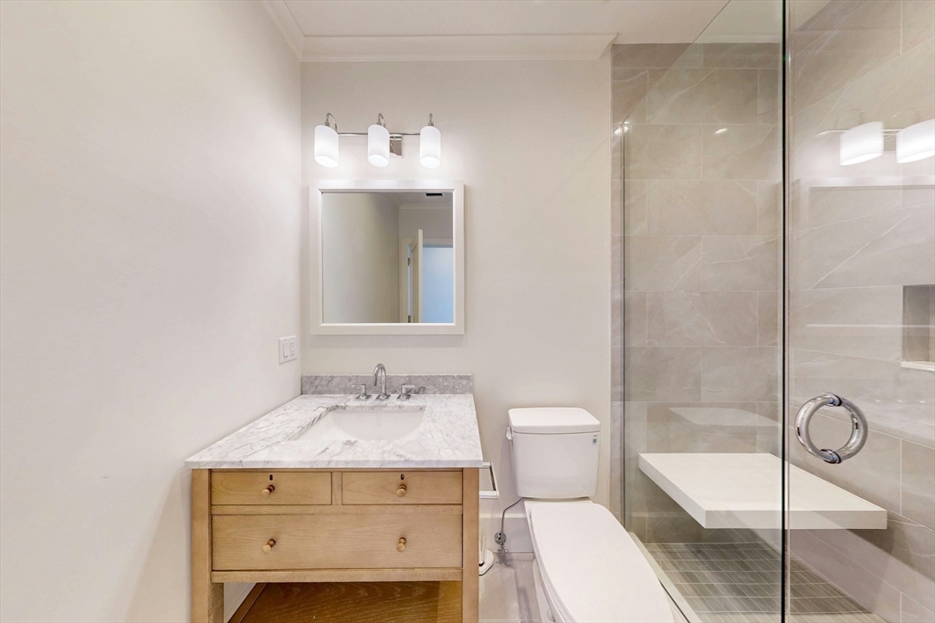 57 Hancock Street Boston, MA 02114 - Photo 31 of 42 a bathroom with a sink a toilet and shower