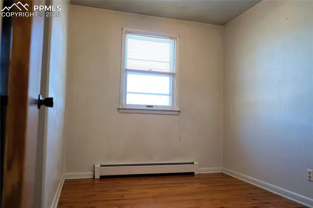 an empty room with wooden floor and a window