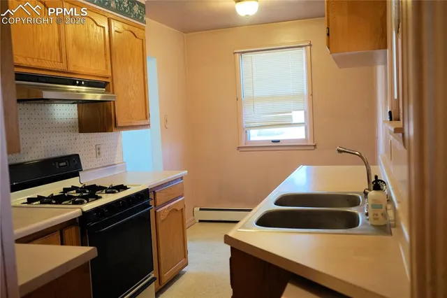 a kitchen with granite countertop a stove and a sink