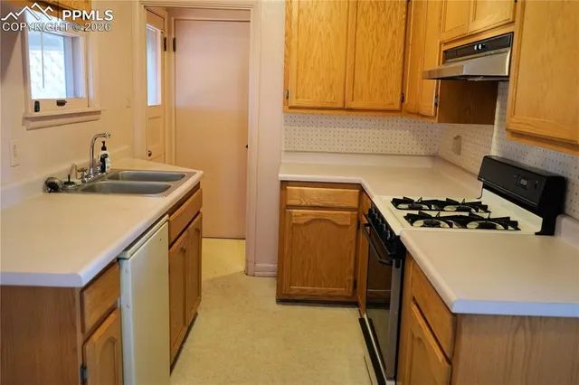 a kitchen with a sink a stove and cabinets