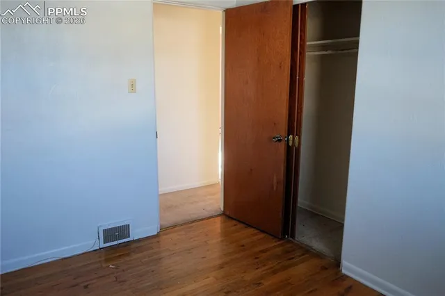 a view of an empty room with wooden floor