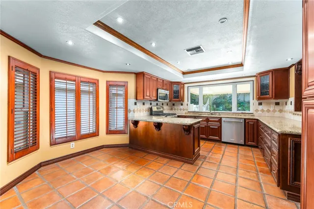 a large kitchen with granite countertop a stove sink and cabinets