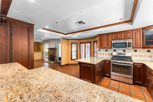 a kitchen with stainless steel appliances granite countertop sink stove and large window