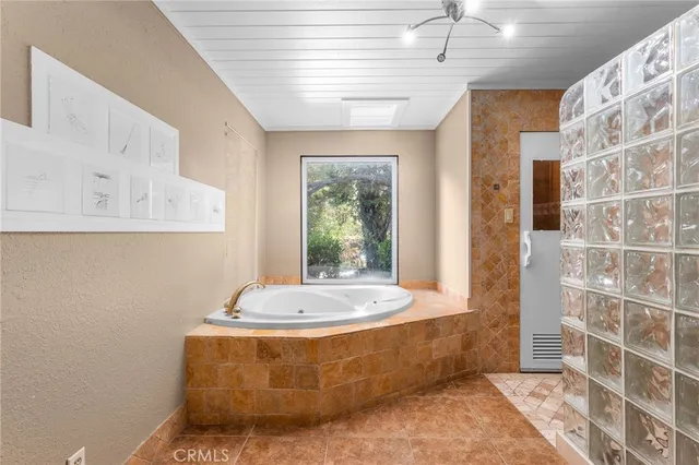 a view of an empty room with window and chandelier fan