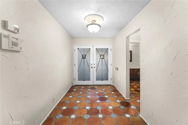a view of a hallway with wooden floor and a chandelier