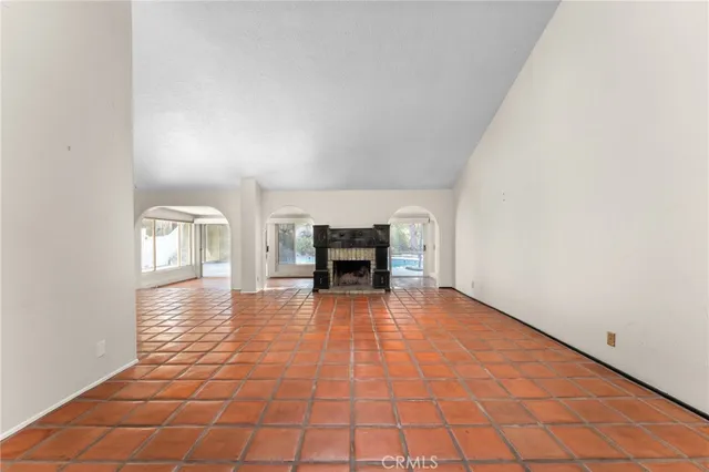 a view of empty room with fireplace and wooden floor
