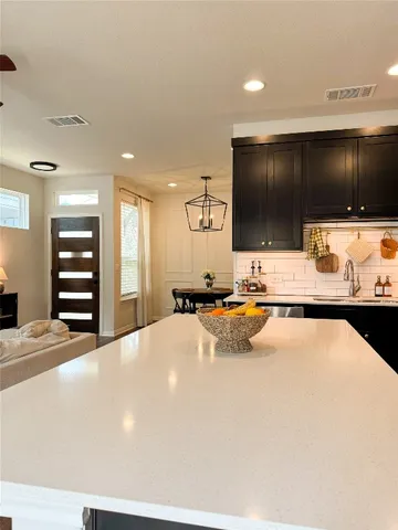 a living room with a flat screen tv and kitchen view