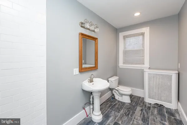 a bathroom with a toilet a sink and mirror
