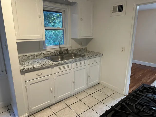 a kitchen with cabinets a stove top oven and cabinetry