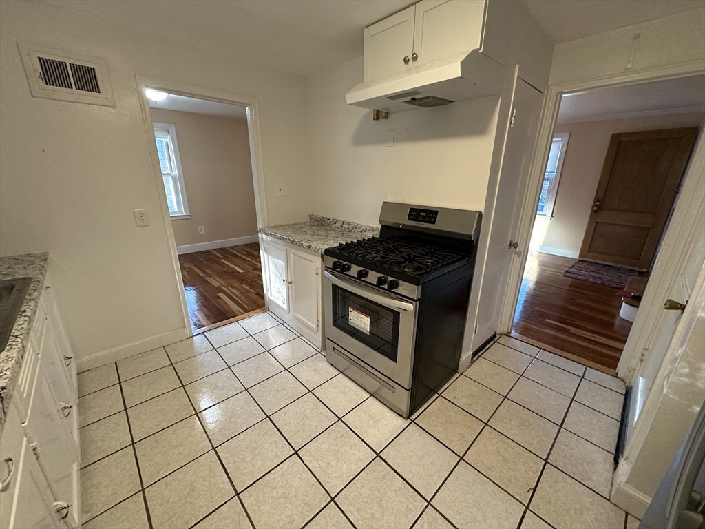 3 Arborcrest Terrace, Unit 2 Boston, MA 02126 - Photo 17 of 29 a kitchen with cabinets a stove top oven and cabinetry