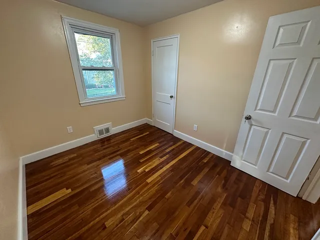 a view of room with window and wooden floor
