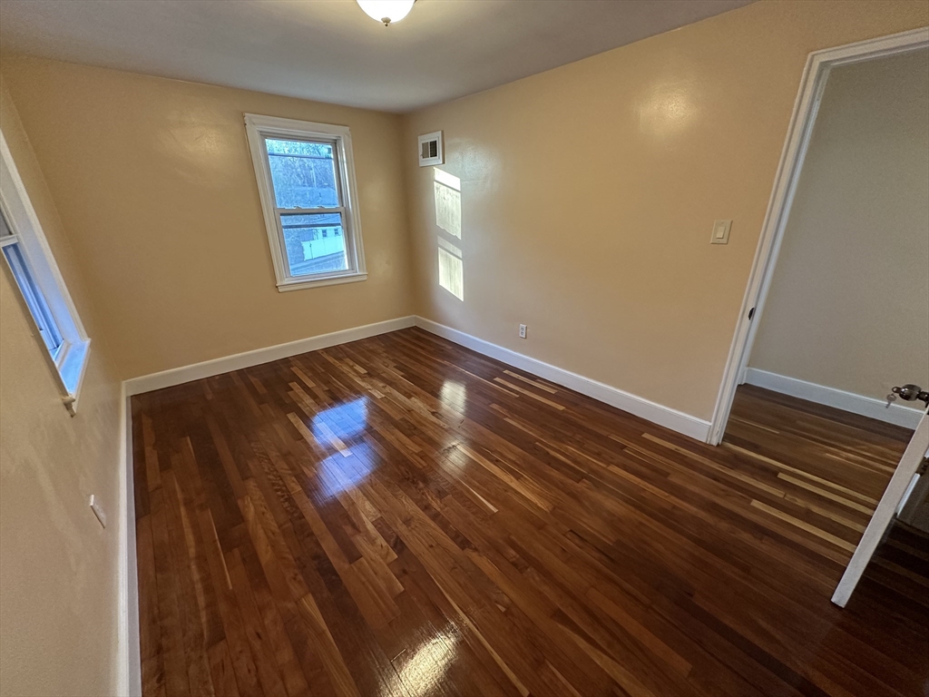 3 Arborcrest Terrace, Unit 2 Boston, MA 02126 - Photo 25 of 29 a view of an empty room with wooden floor and a window