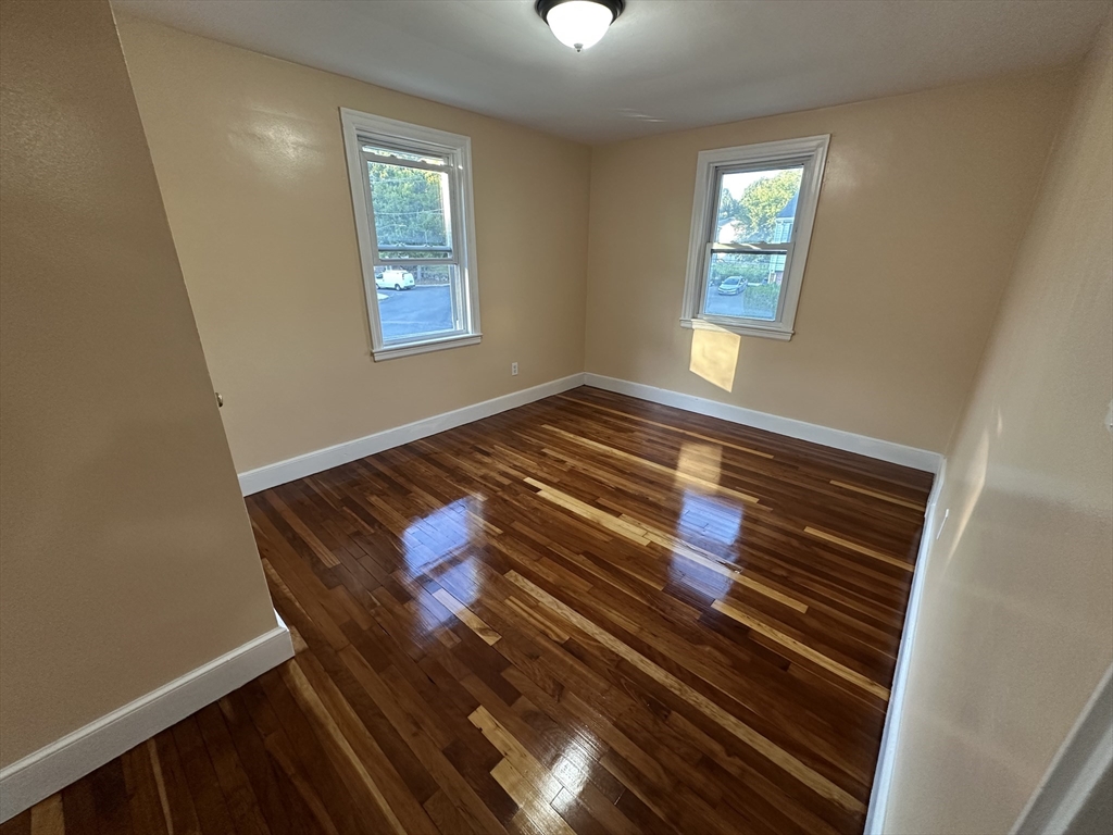 3 Arborcrest Terrace, Unit 2 Boston, MA 02126 - Photo 27 of 29 a view of an empty room with wooden floor and a window