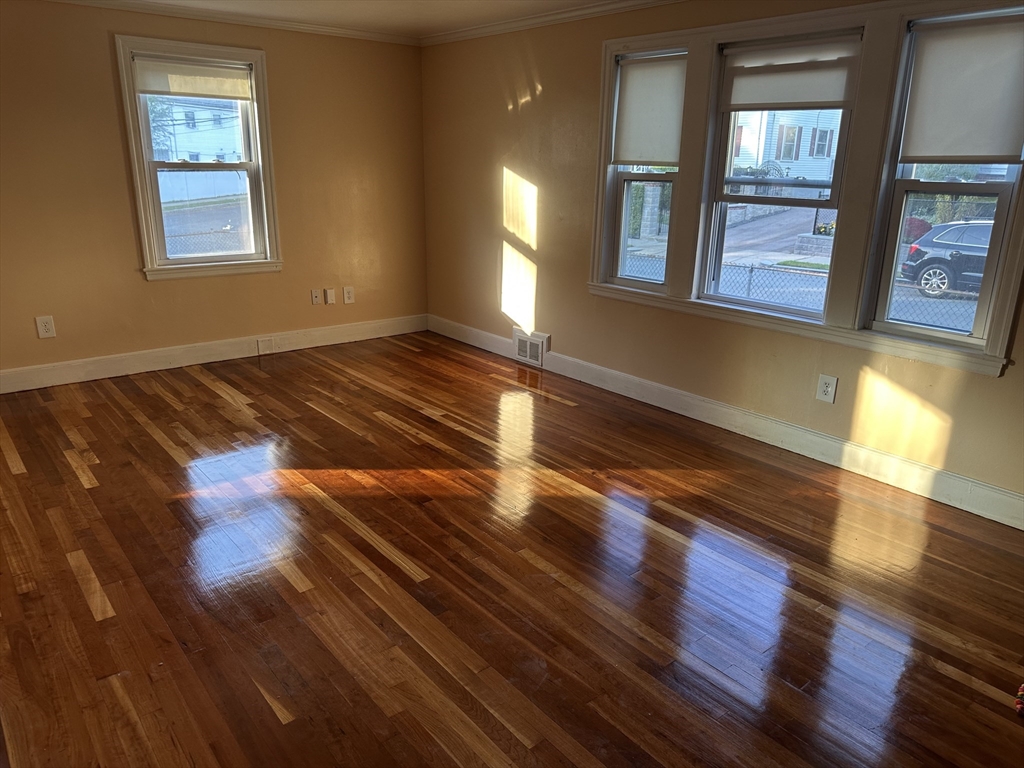 3 Arborcrest Terrace, Unit 2 Boston, MA 02126 - Photo 6 of 29 a view of an empty room with wooden floor and a window