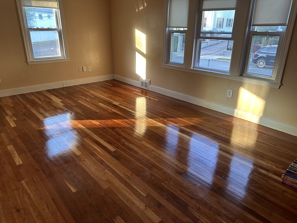 3 Arborcrest Terrace, Unit 2 Boston, MA 02126 - Photo 7 of 29 a view of an empty room with wooden floor and a window