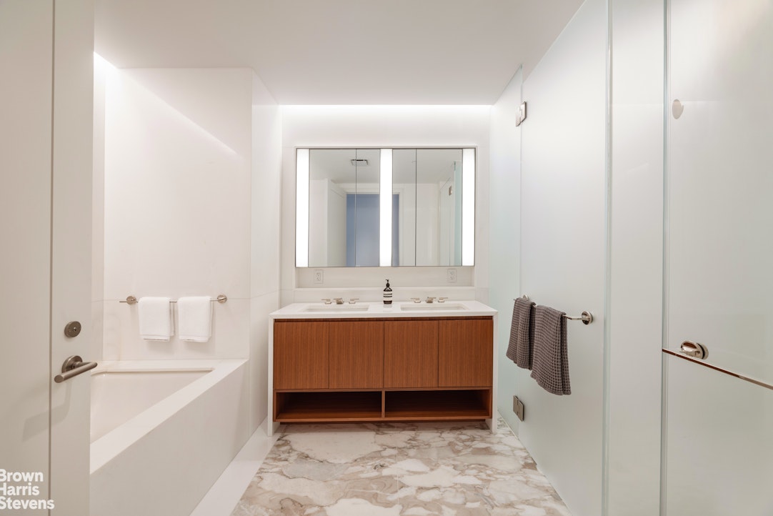 1289 Lexington Avenue, Unit 11D Manhattan, NY 10028 - Photo 8 of 16 a bathroom with a tub sink and mirror