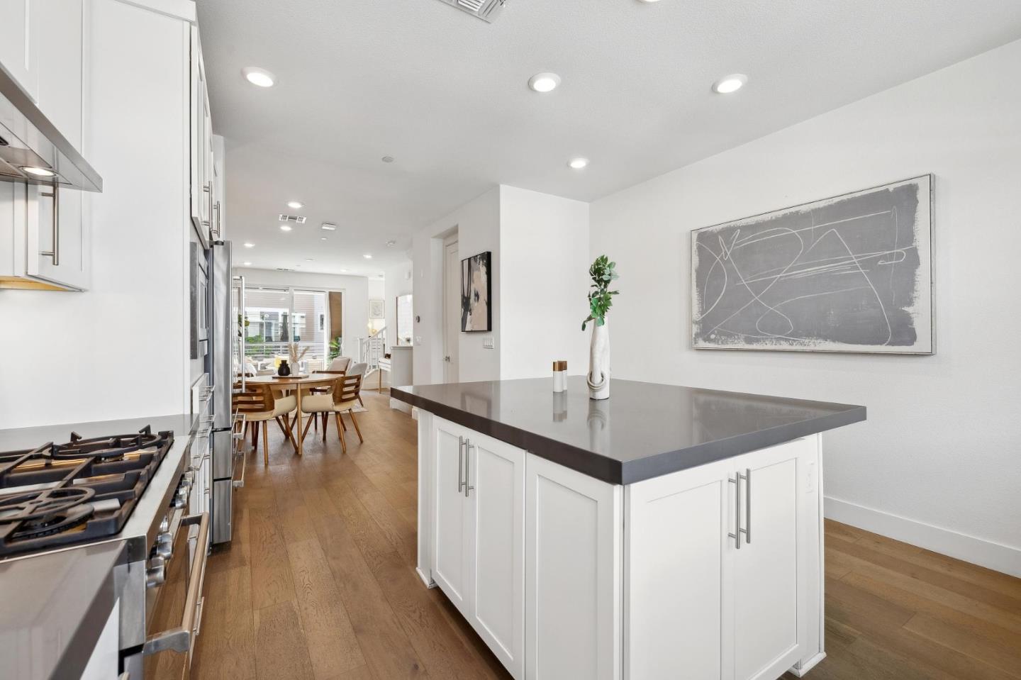 2266 Mora Place Mountain View, CA 94040 - Photo 12 of 32 a kitchen with stainless steel appliances granite countertop a stove top oven a sink a dining table and chairs with wooden floor