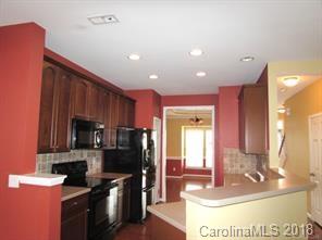 149 Snead Road, Unit 70 Fort Mill, SC 29715 - Photo 4 of 15 a kitchen with stainless steel appliances kitchen island granite countertop a stove a sink and a microwave