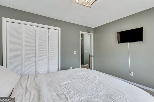 a bedroom with a bed and a flat screen tv