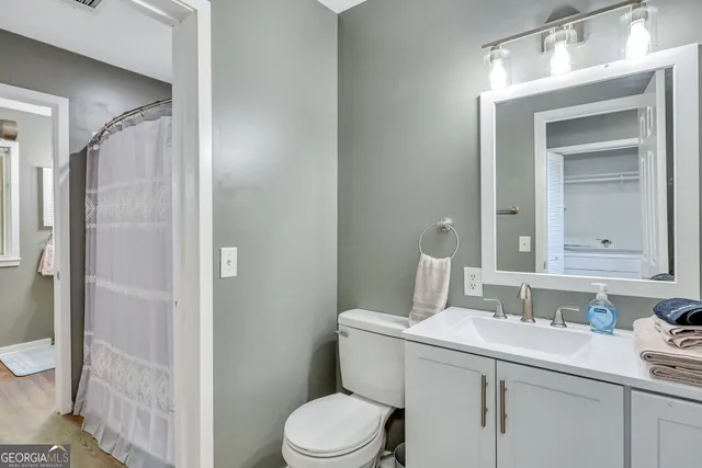 a bathroom with a toilet sink vanity and shower