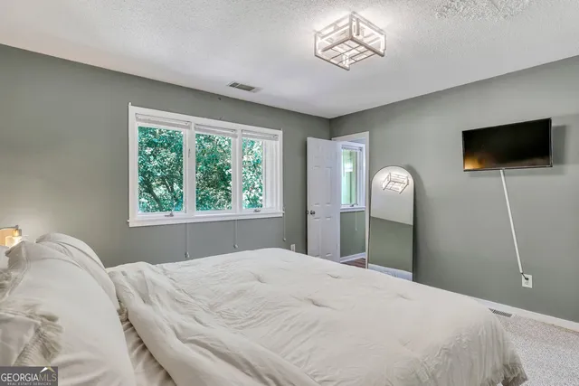 a bedroom with a bed and a flat screen tv