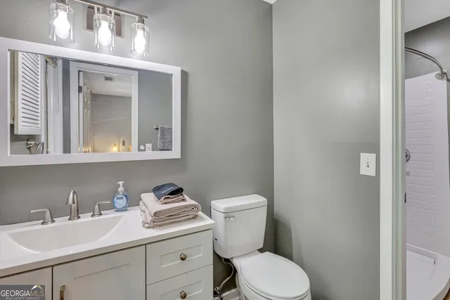 a bathroom with a toilet sink and mirror