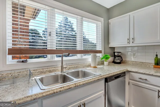 a kitchen with granite countertop a sink and a window