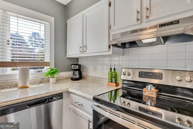a kitchen with stainless steel appliances a sink a stove and cabinets