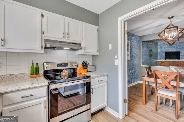 a kitchen with stainless steel appliances granite countertop a stove and cabinets