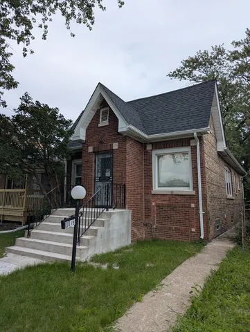 a front view of house with a garden