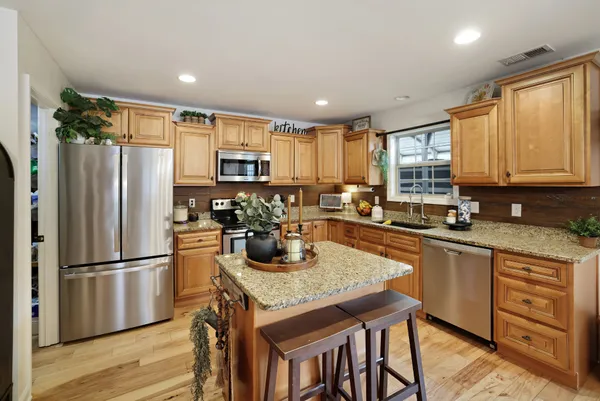 a kitchen with stainless steel appliances granite countertop a sink stove and refrigerator