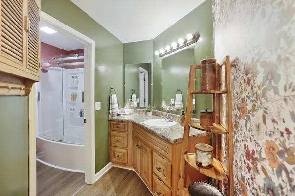 a bathroom with a granite countertop sink toilet mirror and a bathtub